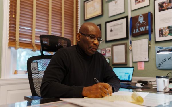 Teacher Jay Farrow 75 at his desk in the office of Access and Equity.