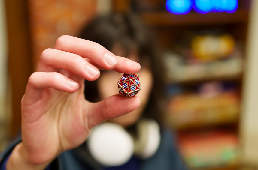 Oliver Hart c24 holds multi-sided die for Dungeons & Dragons.